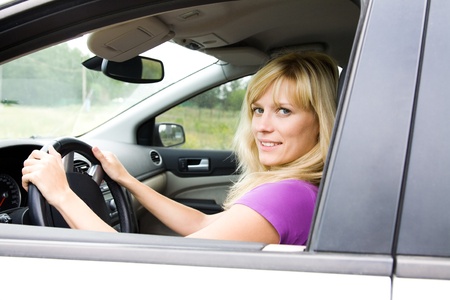 Portrait of young beautiful woman with fair hair sitting in the car の写真素材