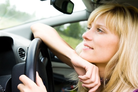 Portrait of young beautiful woman with fair hair sitting in the car の写真素材