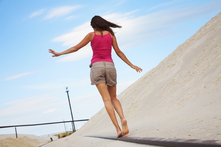 beautiful young girl goes on the rails balancing handsの写真素材