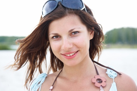 portrait of young beautiful woman with brown hair on  background  of forest and  lakeの写真素材