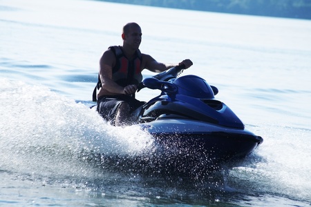 strong man drive on the jetski above the water at sunset .silluet. spray.の写真素材
