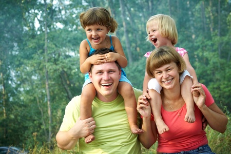family lifestyle portrait of a mum and dad with their children having good time in the green  parkの写真素材