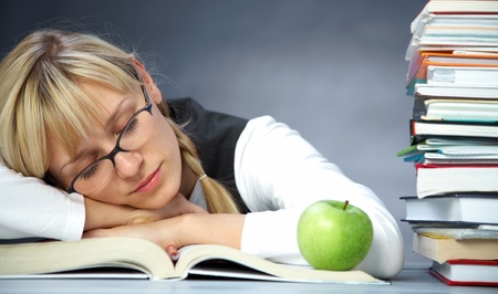 Tiredness girl student sleeps on books in the libraryの写真素材
