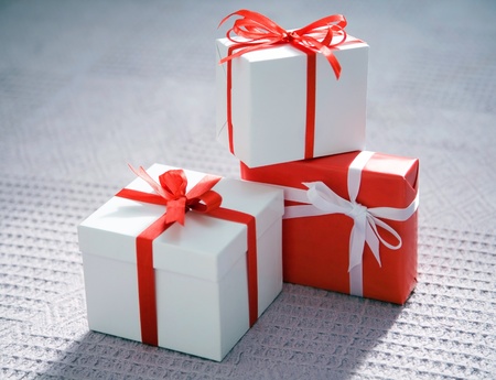 beautiful white presents are tied up by a red tape の写真素材