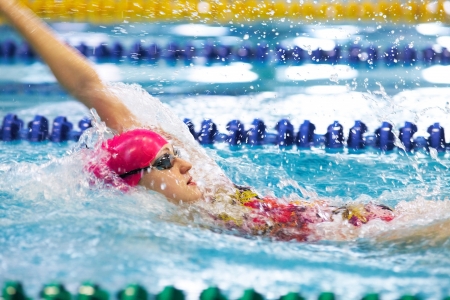 Young girl floating on her back in the poolの写真素材