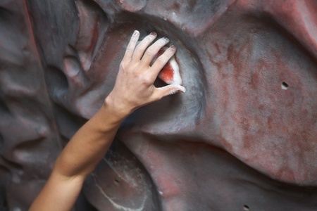 Hand climber clinging tightly to the hook climbing gym