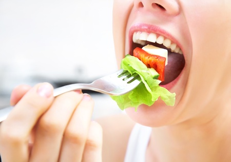 close-up of woman eating fresh saladの写真素材