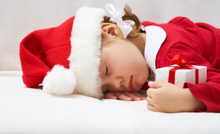 Portrait of sleeping little girl with Christmas presentの写真素材