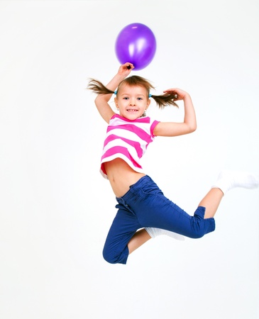 Portrait of cute little girl jumping  with violet  balloonsの写真素材