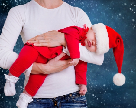 Portrait of Christmas baby is sleeping on motherï¿½s handsの写真素材