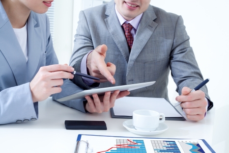 Unrecognizable business colleagues working together and using a digital tabletの写真素材