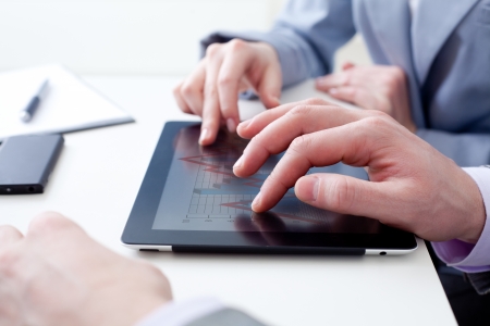 Unrecognizable business colleagues working together and using a digital tabletの写真素材