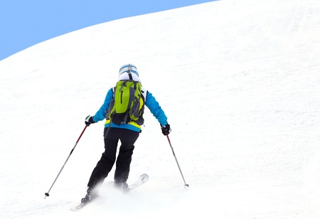 Female skier turning in deep powder with mountains valley'sの写真素材