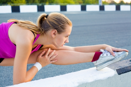 young woman is streching outdoorsの写真素材