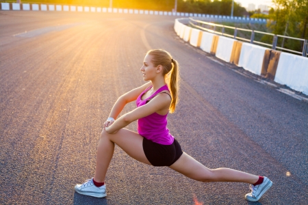 young woman is streching outdoors