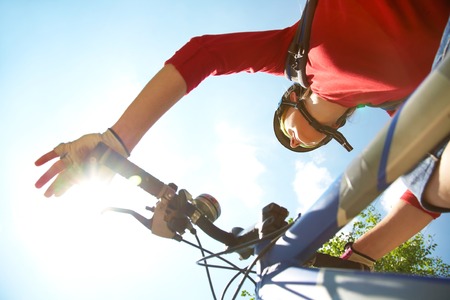 Young cyclist on a mountain bike and the blue sky in the parkの写真素材