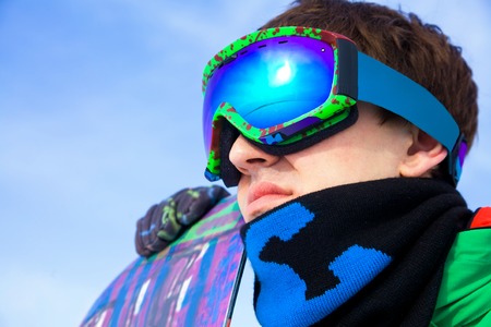 
young man in sport sunglasses with a snowboard. close-upの写真素材