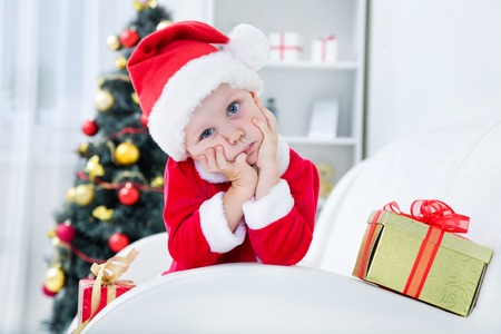 Portrait of adorable boy in santa suit with Christmas presentの写真素材