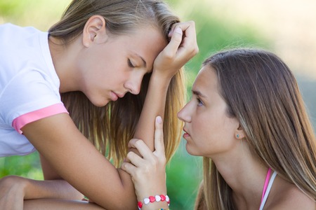young girl comforting her friend in a depressionの写真素材