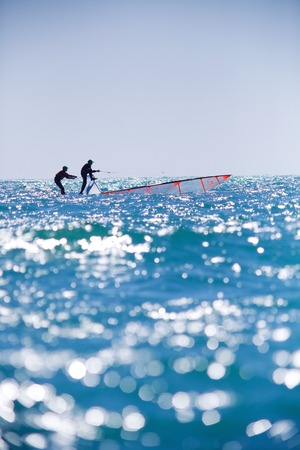 sailing team fighting to save the ship from overturn in sea