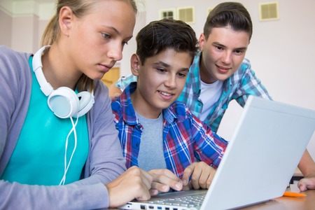 group of young students studying in the classroom with a laptopの写真素材