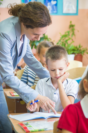 young teacher teaches children in elementary schoolの写真素材