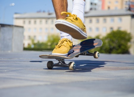 skateboarders feet while skating on concrete at the skate parkの写真素材