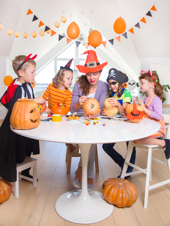 Little kids with their mother paint on the back of the holiday on Halloween.の写真素材