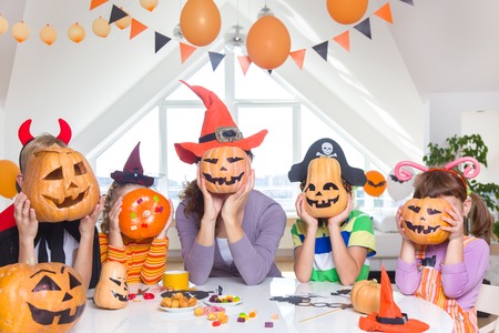 happy family celebrates halloween at home. People keep pumpkins instead of heads.の写真素材