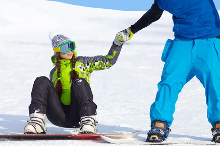 young couple of snowboarders learns to ski in a ski resortの写真素材