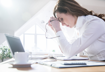 Portrait of exhausted businesswoman in officeの写真素材