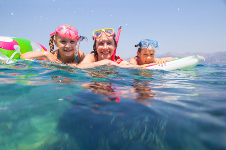 happy family with children is swimming and having fun in the sea on an inflatable mattress. の写真素材