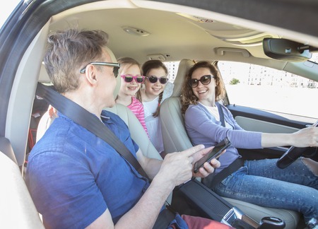 young family with children is traveling in a car on a journey. View inside the machineの写真素材