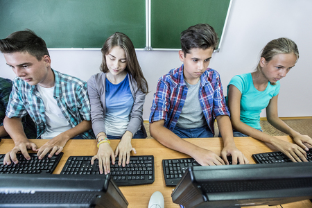 Group of students working at computers in classroomの写真素材