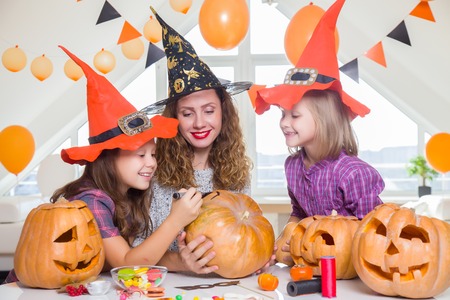 two little girls with their mother paint on the back of the holiday on Halloween.の写真素材