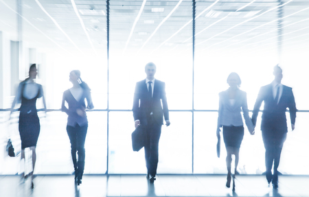 group of young business people are actively moving around the large officeの写真素材