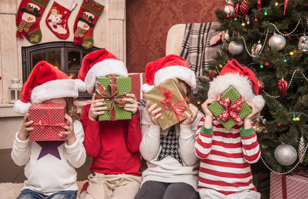 Group of four children with presents on Christmas partyの写真素材