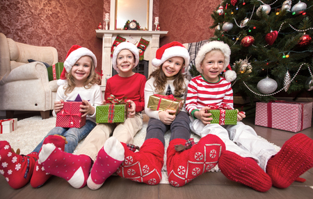 Group of four children with presents on Christmas partyの写真素材
