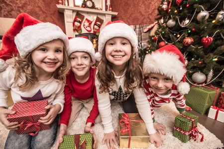 Group of four children with presents on Christmas partyの写真素材