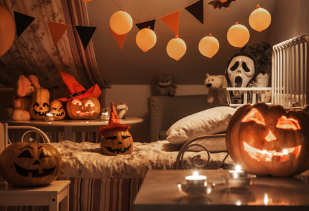 interior of a children's bedroom decorated for  Halloween holiday in the night illuminationの写真素材