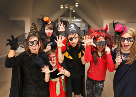 group of funny  children in costume celebrate together a halloween partyの写真素材