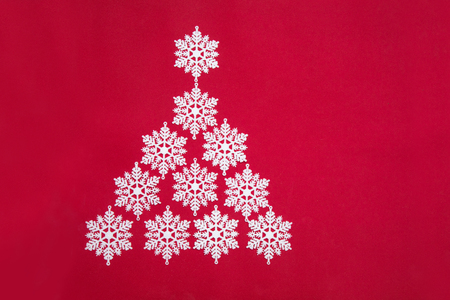 Beautiful Christmas tree of decorative snowflakes on a red backgroundの写真素材