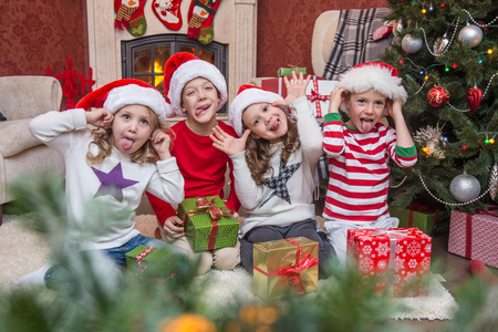 Group of four children with presents on Christmas partyの写真素材