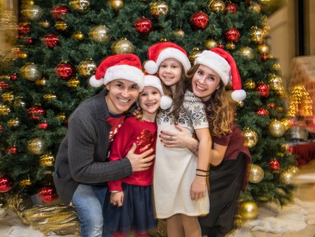 happy family celebrating Christmas near the fireplace under the Christmas treeの写真素材