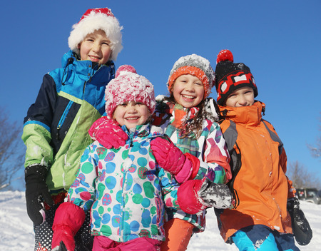 Group of children playing on snow in winter time