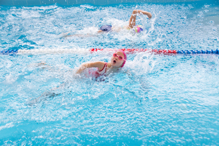 little  girls swimming in blue  poolの写真素材