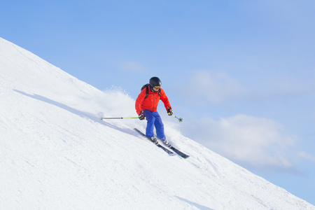 Man skiing on a snowy road in the mountainsの写真素材