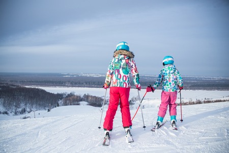little girls skiing  to ski slope  in the winter  mountain resortの写真素材
