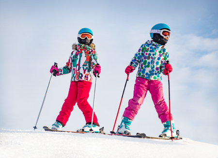 little girls skiing  to ski slope  in the winter  mountain resortの写真素材