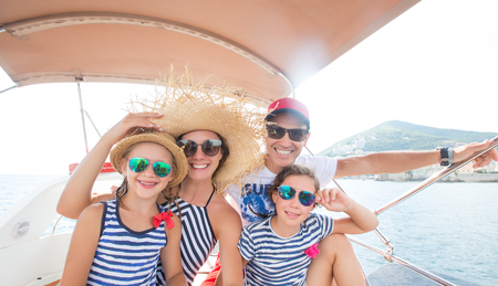 Happy family with children enjoy relaxing on a yacht at seaの写真素材